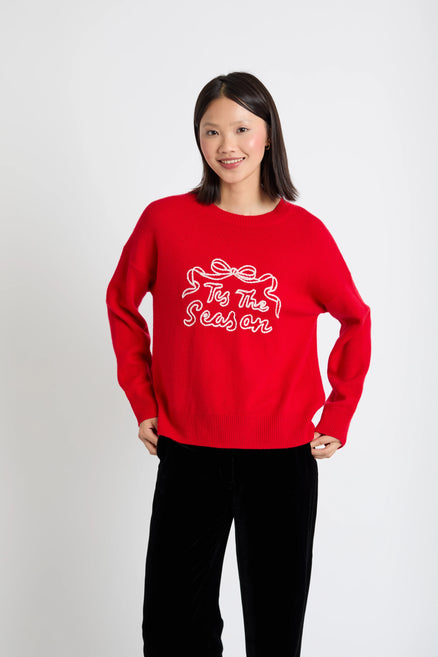 Person wearing a red sweater with white text on a plain background