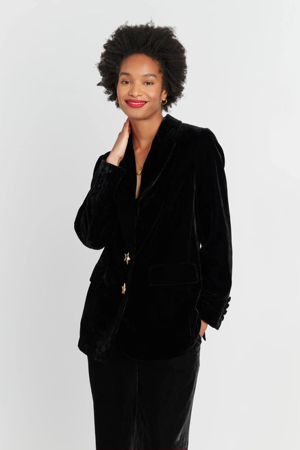 Woman wearing a black velvet blazer against a white background