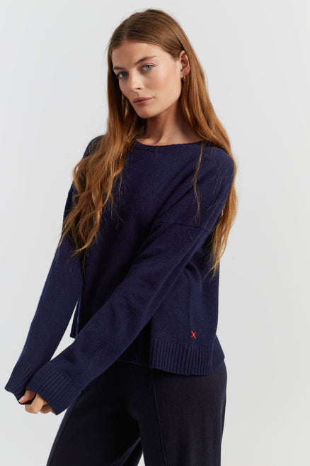 Woman wearing a navy blue sweater on a white background