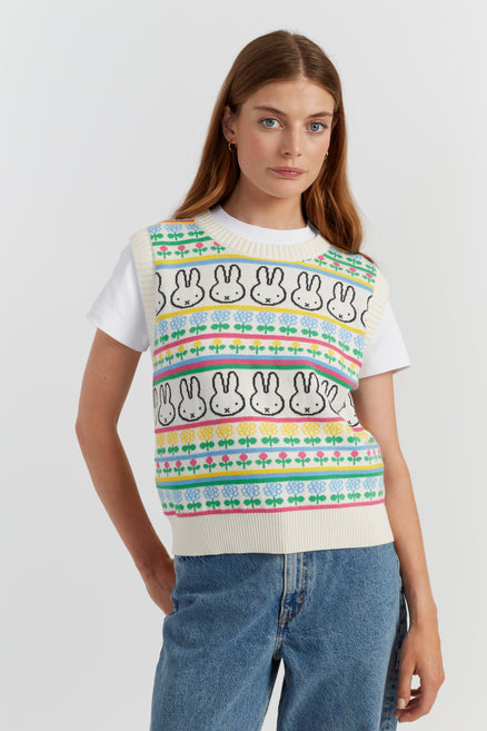 Woman wearing a colorful sweater with rabbit patterns on a white background