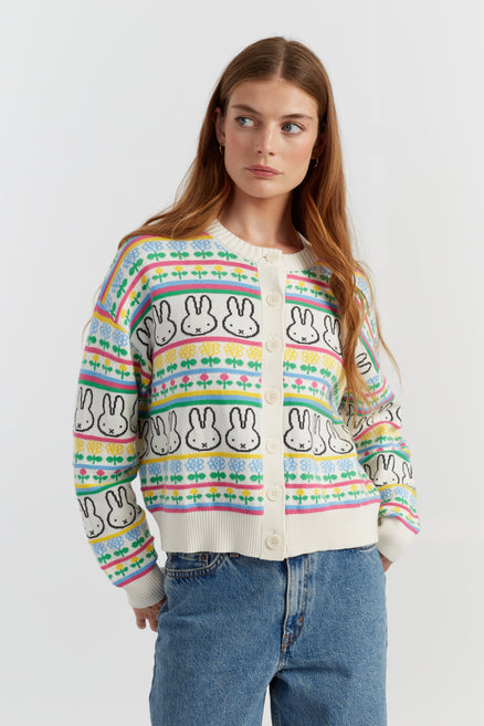 Woman wearing a colorful cardigan with bunny pattern against a white background