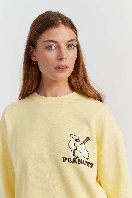 Person wearing a yellow sweatshirt with a cartoon character and 'Peanuts' text on a white background